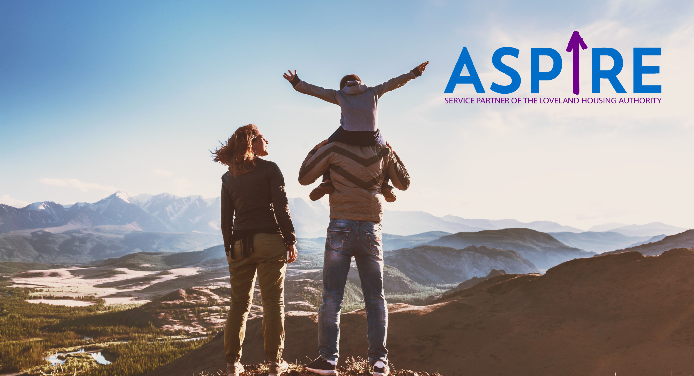 A family stands on a mountain peak overlooking a scenic valley; a child sits on an adult's shoulders with arms outstretched. The word "ASPIRE" and a tagline appear in the sky.